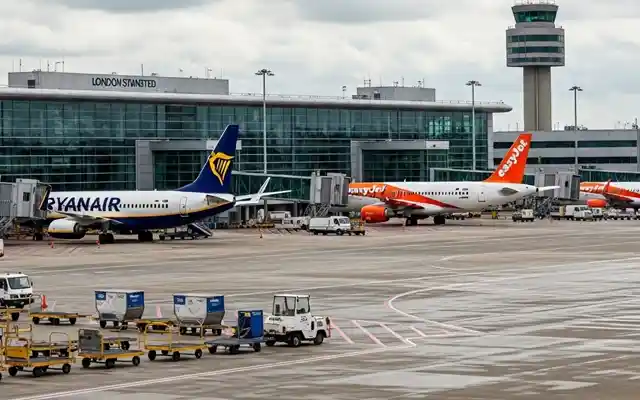 Comprehensive map showing free and paid parking locations near London Stansted Airport with costs, distances, and transport links to terminal